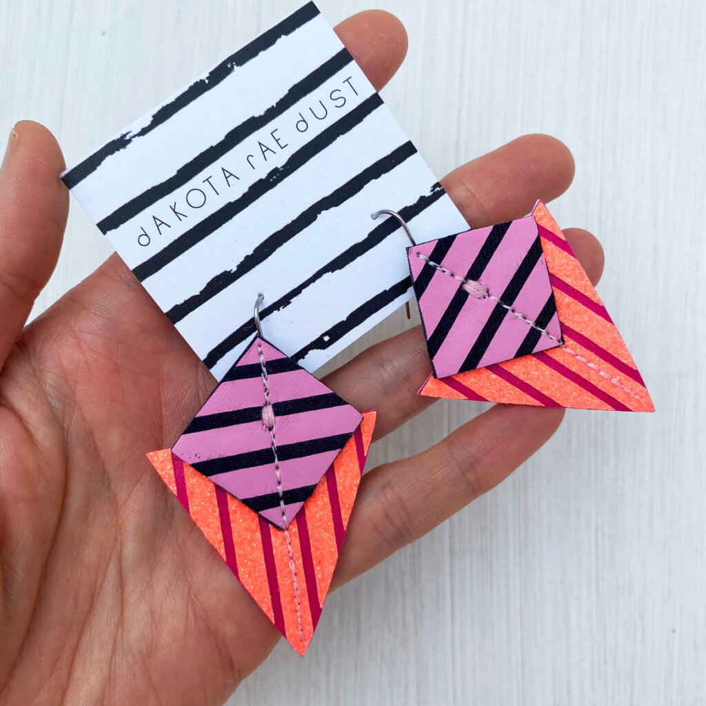 A colourful pair of graphic stripe earrings held in an open hand